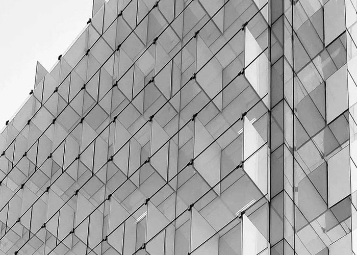 Glass curtain wall facade of a modern commercial building.